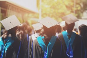 Graduates stand at ceremony.
