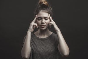 teenage girl holding her head. concentrate and focus concept