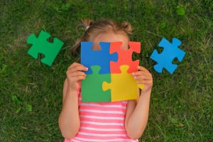 A color puzzle made of elements in the hands of a child suffering from autism syndrome. Brainteasers for the development and education of children