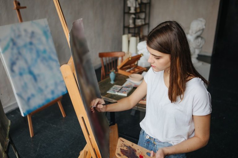Artist painter young beautiful girl. Working creating process. painting on easel. inspired work