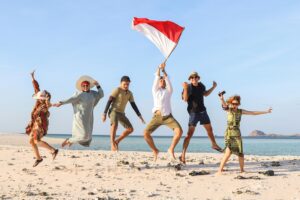 Group of people jumping together on the beach for celebrating Indonesia