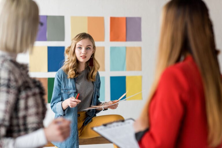 selective focus of fashionable magazine editors working in modern office with color palette