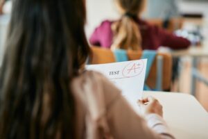 Cloe-up of schoolgirl getting A+ grade on exam at elementary school.