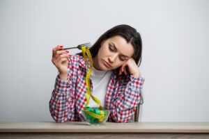 Concept of growing thin girl with a plate full of tape.