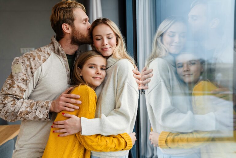 Beautiful happy young family hugging and kissing indoors