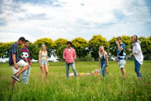 Group of multiethnic teenagers spending time outdoor on a picnic at the park