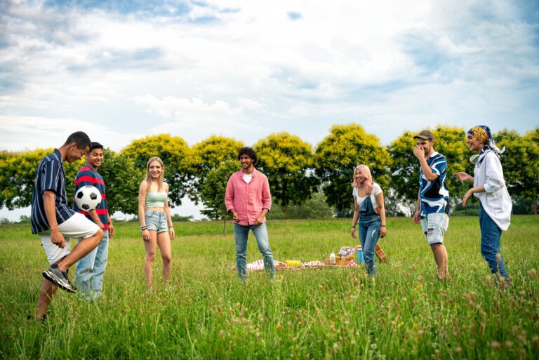 Group of multiethnic teenagers spending time outdoor on a picnic at the park