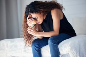 young, teenage woman holding a plushie while crying showcasing concept of grief
